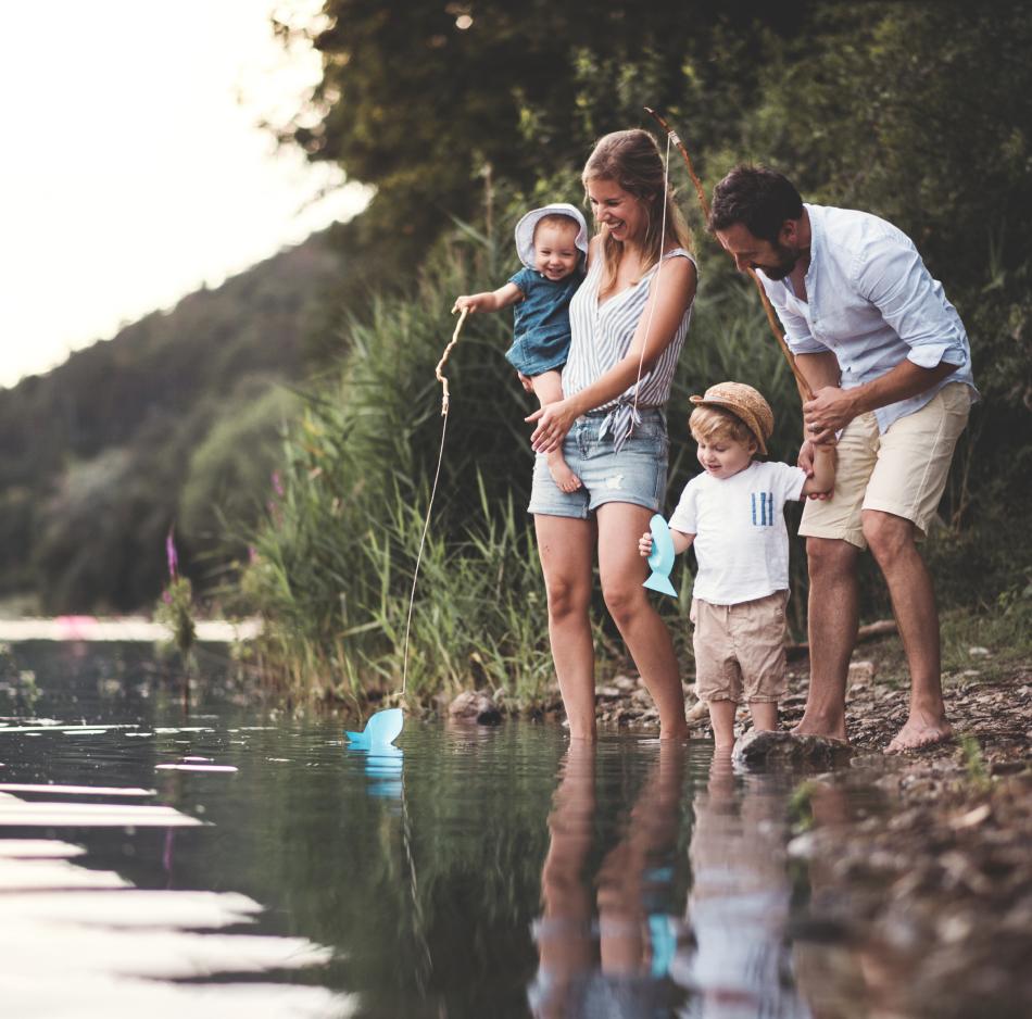 Een papa en mama die samen met hun zoon en dochter gaan vissen.